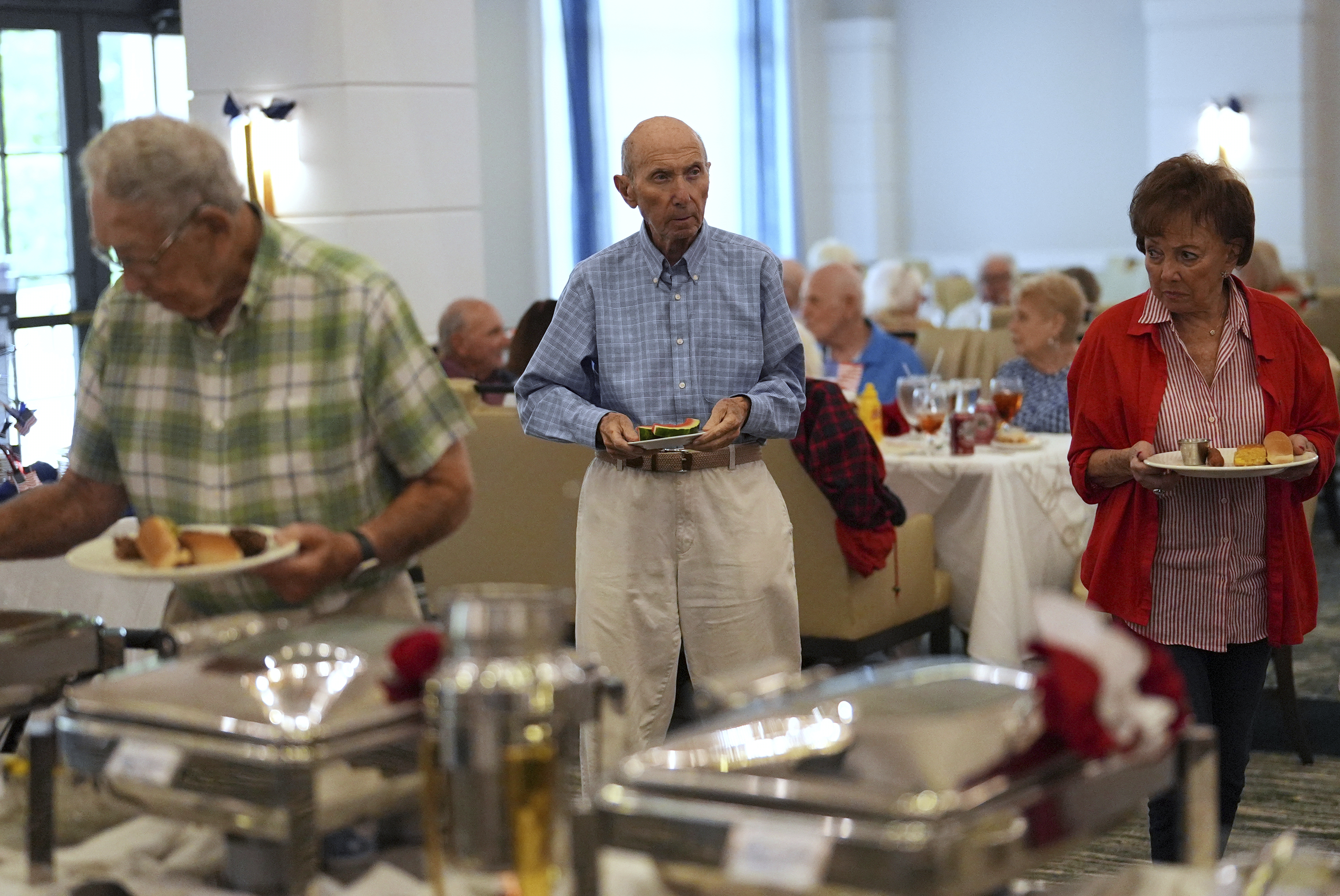 Residents of the independent living facility at the Toby and Leon Cooperman Sinai Residences partake in an Independence Day buffet, July 4, 2025, in Boca Raton, Fla. (AP Photo/Rebecca Blackwell)