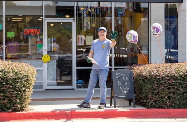 As guest relations specialist, Glenn Hutchinson waves to passerby in front of Glenn's Cafe in Mableton. (Phil Skinner of the AJC) 