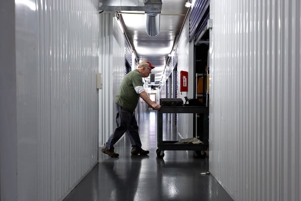 Tom Rehkopf, 82, brings typewriters into a unit at a public storage facility in Roswell. Rehkopf has collected around 1,000 typewriters. (Arvin Temkar / AJC)