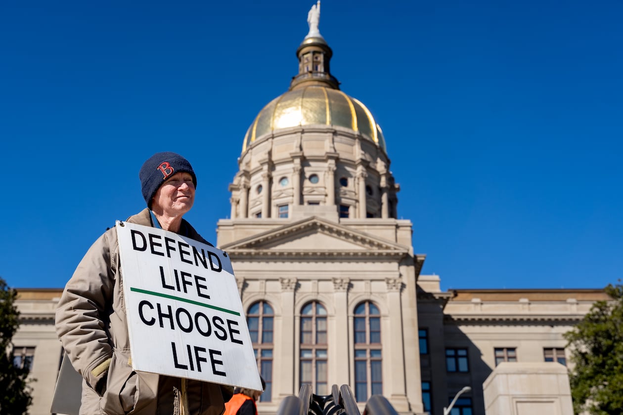 Jack Harvey holds a sign that reads “Defend life, choose life” during a silent march in the streets of downtown Atlanta to commemorate the anniversary of the 1973 Supreme Court ruling in Roe v. Wade on Friday, Jan. 24, 2025. (Ben Hendren for the AJC)