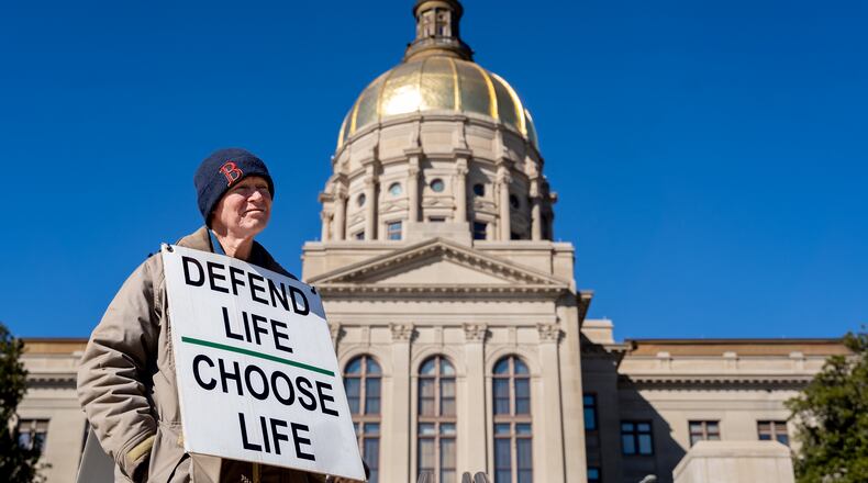Jack Harvey holds a sign that reads “Defend life, choose life” during a silent march in the streets of downtown Atlanta to commemorate the anniversary of the 1973 Supreme Court ruling in Roe v. Wade on Friday, Jan. 24, 2025. (Ben Hendren for the AJC)