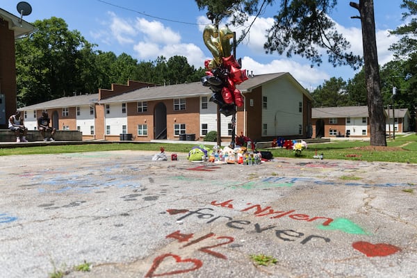 Stuffed animals, snacks and drinks rest at the base of a basketball goal with balloons in memoriam of Ja’Nylen Greggs in Atlanta on Friday, June 20, 2025. The apartment complex community is mourning 12-year-old Greggs after he was killed in the crossfire of a drive-by shooting. (Abbey Cutrer / AJC)