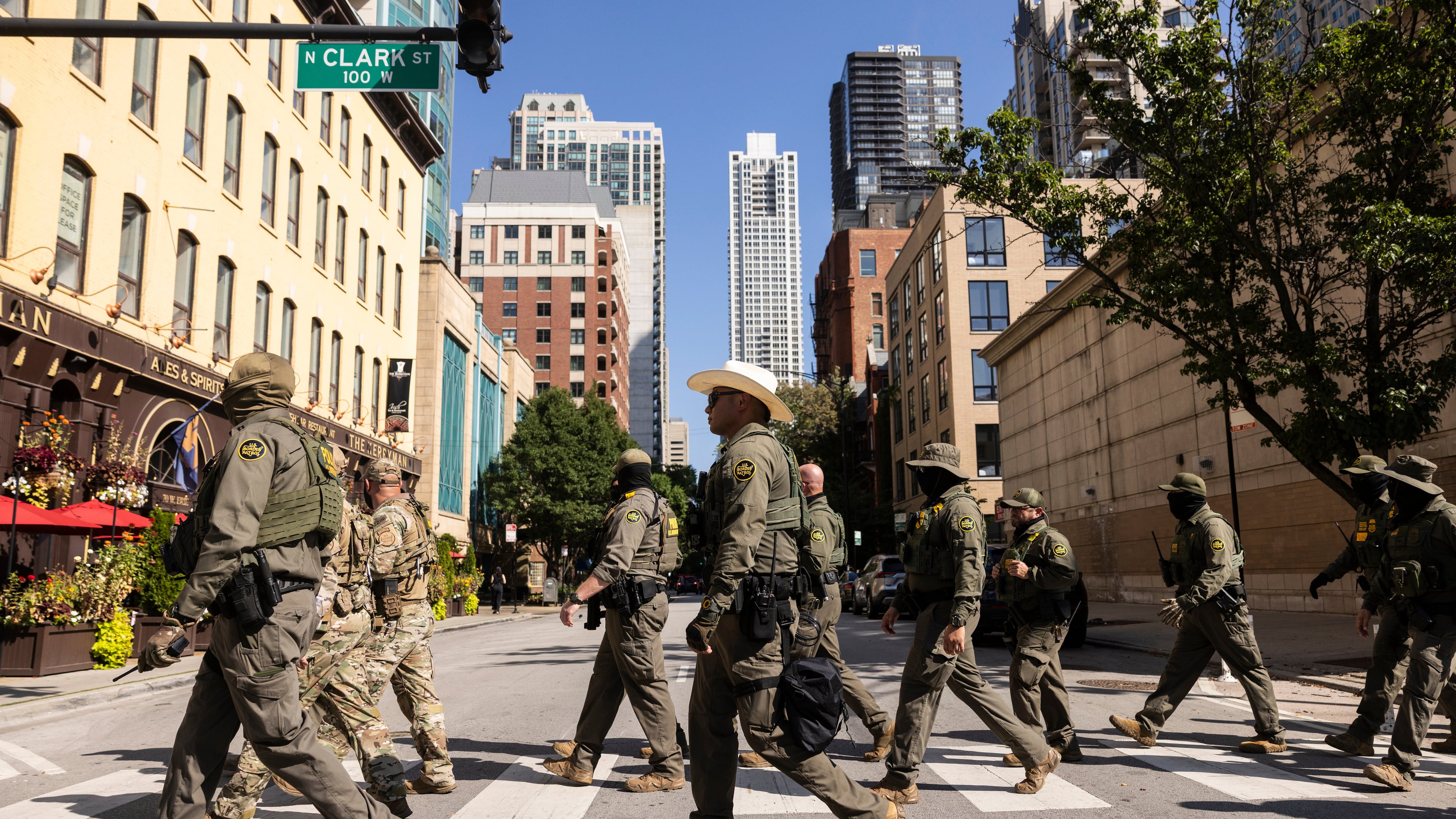 Federal agents from U.S. Immigration and Customs Enforcement and U.S. Customs and Border Protection walk north on North Clark Street in the River North neighborhood, Sunday, Sept. 28, 2025, in Chicago. (Ashlee Rezin/Chicago Sun-Times via AP)