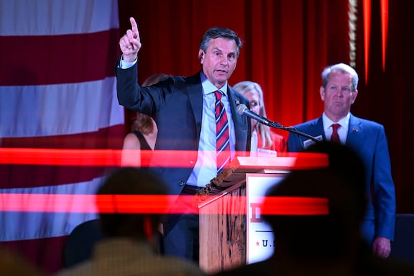 Republican candidate for U.S. Senate Derek Dooley (center) speaks to supporters at his election night party Tuesday, May 19, 2026, as Georgia Gov. Brian Kemp watches. (Daniel Varnado/AJC)