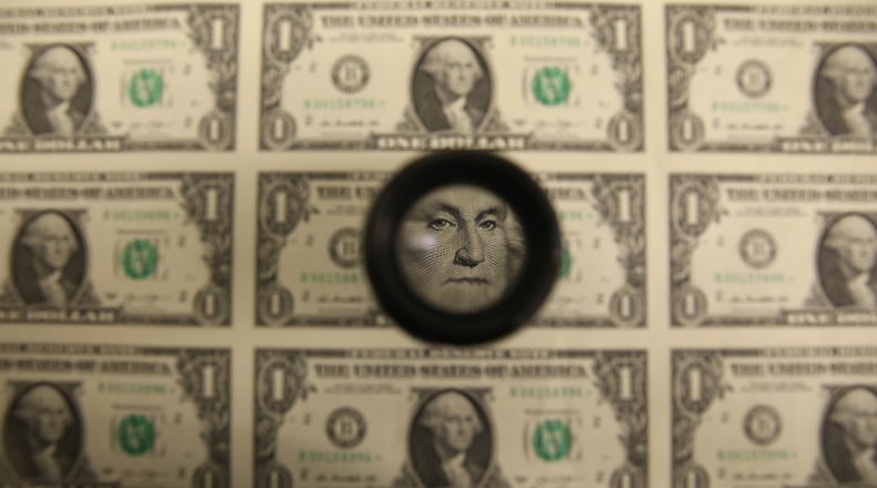A magnifying glass is used to inspect newly printed one dollar bills at the Bureau of Engraving and Printing on March 24, 2015 in Washington, DC.