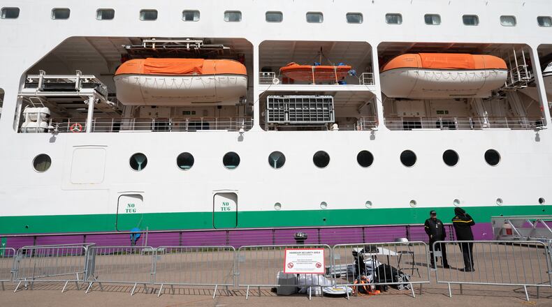 A barrier is set in front of the British cruise ship Ambition, as French authorities have ordered 1,700 passengers and crew to stay on board due to a gastrointestinal illness outbreak, in Bordeaux, southwestern France, Wednesday, May 13, 2026. (AP Photo/Caroline Blumberg)