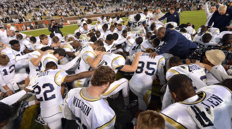 Georgia Tech’s chaplain Derrick Moore prays with the football team after defeating the Miami Hurricanes at Bobby Dodd Stadium on Saturday, October 4, 2014. HYOSUB SHIN / HSHIN@AJC.COM