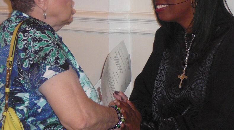 Rev. Claudette Farmer greets church member Rosemary Strickland after a service at the First United Methodist Church of Marietta. Farmer, who is the only minority on the staff, left the corporate world to go into the ministry.