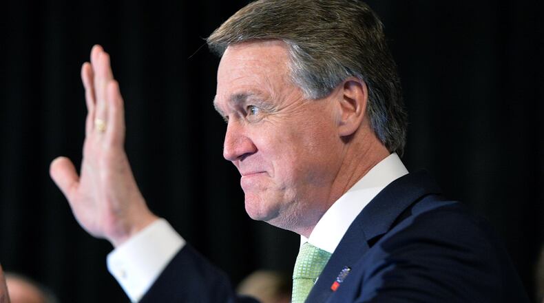 David Perdue waves to his supporters at his election night party at Doubletree Hotel in Buckhead on May 20, 2014. Perdue served on the Georgia Ports Authority while a business he owned with his cousin, former Gov. Sonny Perdue, trucked goods to and from the port. HYOSUB SHIN / HSHIN@AJC.COM