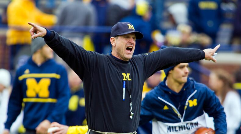Michigan head coach Jim Harbaugh shouts instructions to his players on the Michigan Stadium field during warmups before an NCAA college football game against Michigan State in Ann Arbor, Mich., Saturday, Oct. 17, 2015. (AP Photo/Tony Ding)
