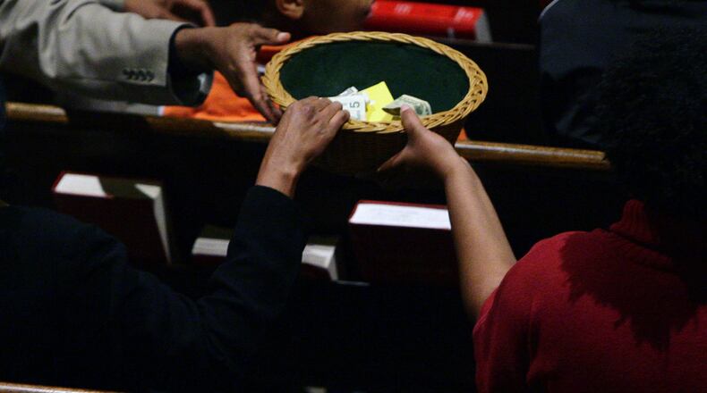 Members at a Decatur church pass around the collection plate. During the coronavirus crisis, churches must rely more on online giving, but not all churches and members are accustomed to that yet. JOSH D. WEISS / SPECIAL