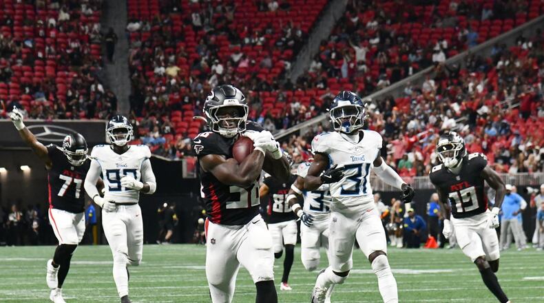 Falcons running back Nathan Carter (center) runs for a 43-yard touchdown during their preseason game Friday, Aug. 15, 2025, at Mercedes-Benz Stadium, in Atlanta. Carter was the primary ball carrier for Atlanta and rushed nine times for 63 yards and the TD. (Hyosub Shin/AJC)