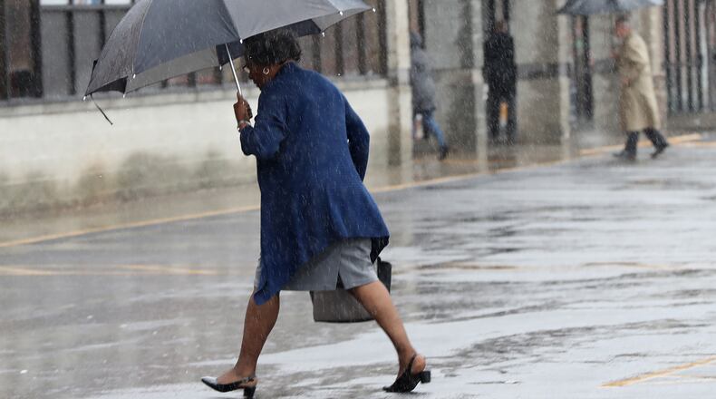 Umbrellas are prevalent as shoppers make their way in and out of stores at The Shoppes at Martin’s Crossing in the rain on Sunday, January 28, 2018, in Covington.