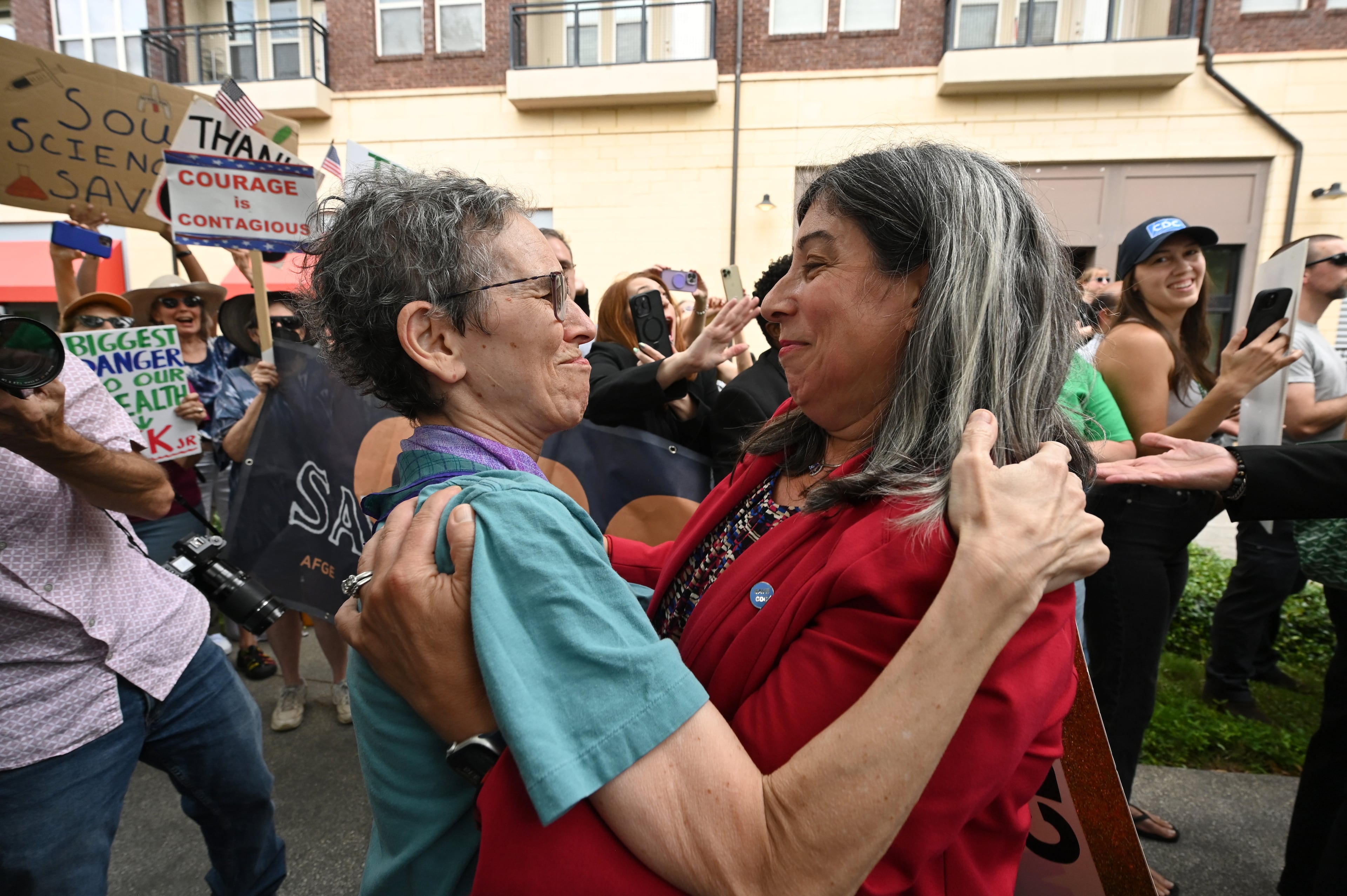 Dr. Debra Houry (right), the agency's deputy director, gets a hug as CDC staff and supporters gather to rally for departing leaders outside the CDC headquarters, Thursday, August 28, 2025, in Atlanta. Top leaders who resigned their positions at the US Centers for Disease Control and Prevention after the ouster of the agency’s director were escorted out of the building Thursday morning. (Hyosub Shin / AJC)