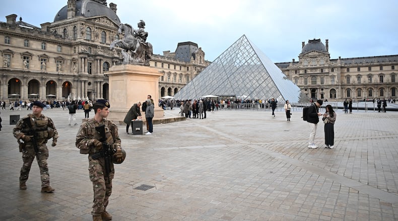 FILE - Soldiers patrol as people queue to try to enter the Louvre museum, although it remains closed for the day after Sunday's jewels robbery, Monday, Oct. 20, 2025 in Paris. (AP Photo/Emma Da Silva, File)