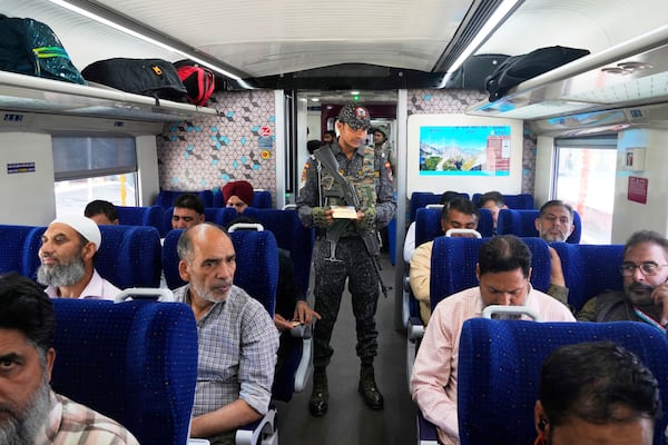 An armed commando inspects tickets inside Vande Bharat Express train soon to be inaugurated to run between Srinagar and Katra, in Srinagar, Indian controlled Kashmir, Friday, June 6, 2025. (AP Photo/Dar Yasin)