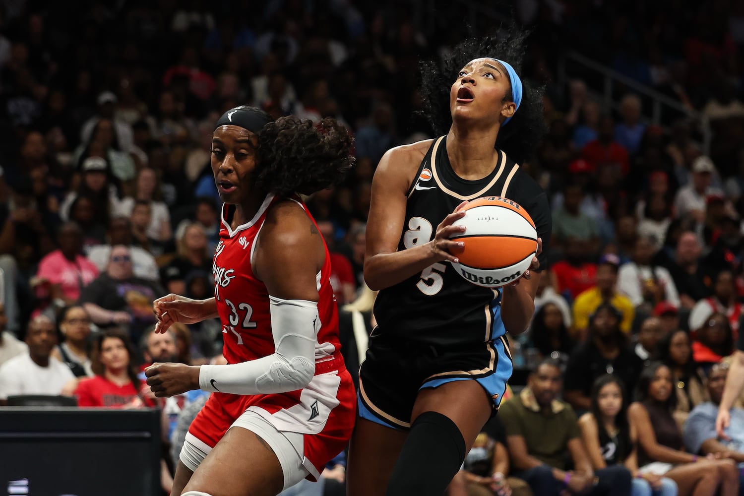 Dream forward Angel Reese (right) drives to the basket past Aces forward Cheyenne Parker-Tyus during the first half Sunday, May 17, 2026, at State Farm Arena in Atlanta. (Colin Hubbard for the AJC) 