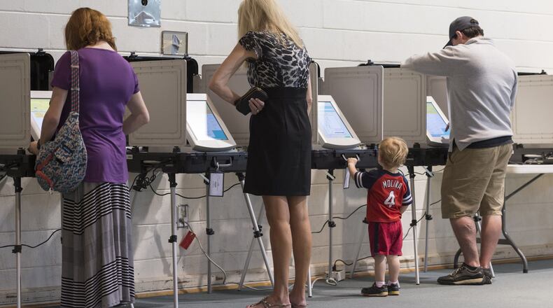 AJ Seger, center right, 2, stands at a voting machine while his mother Mindy Seger, far left, 38, casts her ballot at Mt. Zion United Methodist Church in Marietta, Georgia, on Tuesday, April 18, 2017. Cobb, Fulton and North DeKalb residents cast ballots today for the highly contested 6th Congressional District race. (DAVID BARNES / DAVID.BARNES@AJC.COM)