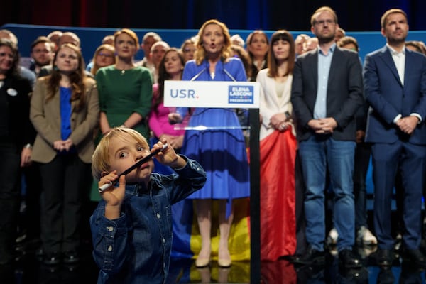 FILE - A child plays as Elena Lasconi, the Save Romania Union (USR) party candidate in the country's presidential elections, speaks to supporters after making it to the Dec. 8, runoff in Bucharest, Romania, Nov. 25, 2024. (AP Photo/Vadim Ghirda, File)
