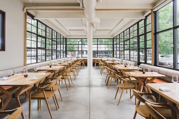 A view down a long dining room with walls of windows on three sides.