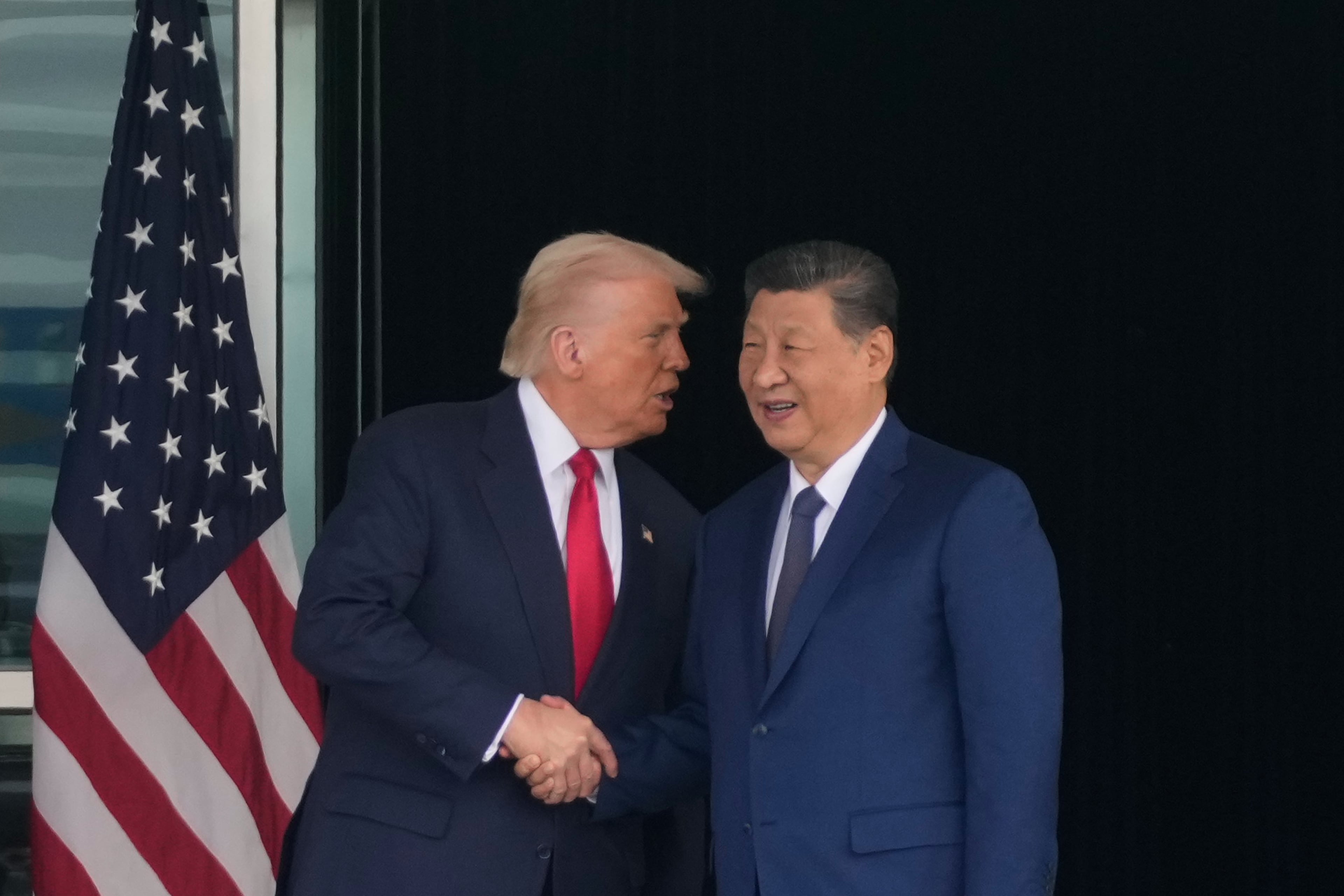 President Donald Trump (left) and President Xi Jinping of China, shook hands today after their meeting in Busan, South Korea. (Mark Schiefelbein/AP)