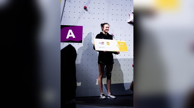 Speed rock climber Emma Hunt smiles with ticket after qualifying for 2024 Paris Olympics at the world championships in Bern, Switzerland.