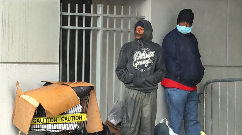 April 19, 2020 Atlanta: Homeless men seek shelter with their belongings near Atlanta City Hall while storms move through the area on Sunday, April 19, 2020, in Atlanta. Curtis Compton ccompton@ajc.com
