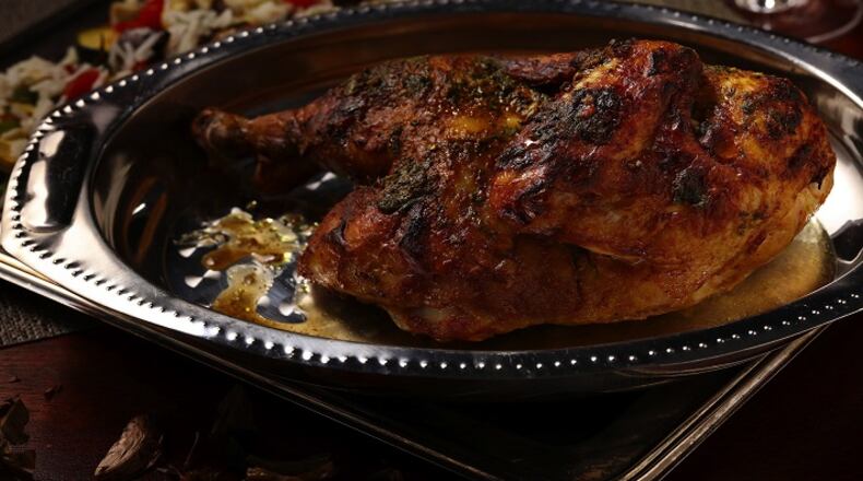 A split chicken is easier to work with than a spatchcocked bird. Before roasting, cut out the backbone with kitchen shears, then split the bird in half through the breast bone with a large chef's knife. (Mark Graham/food styling) (E. Jason Wambsgans/Chicago Tribune/TNS)