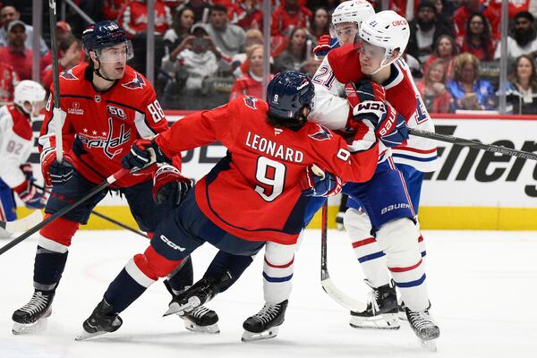 Montreal Canadiens defenseman Kaiden Guhle (21) brings down Washington Capitals right wing Ryan Leonard (9) in the first period of Game 1 of a first-round NHL hockey playoff series Monday, April 21, 2025, in Washington. (AP Photo/Nick Wass)