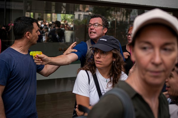 A protester holds a water gun during a protest against overtourism in Barcelona, Spain, Sunday, June 15, 2025. (AP Photo/Pau Venteo)