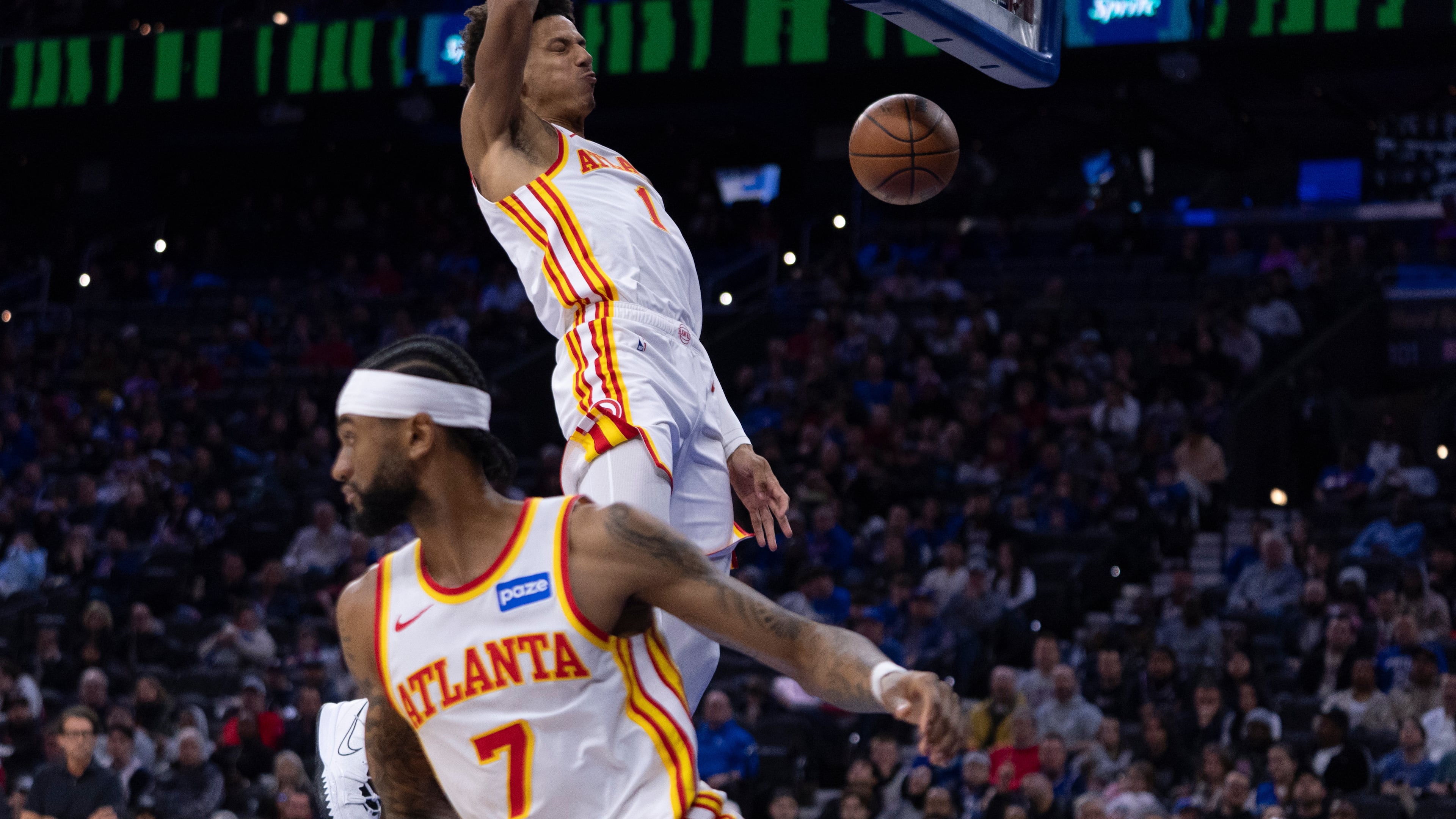 Atlanta Hawks' Jalen Johnson, right, dunks the ball from the pass by Nickeil Alexander-Walker, left, during the first half of an NBA basketball game against the Philadelphia 76ers, Sunday, Nov. 30, 2025, in Philadelphia. (AP Photo/Chris Szagola)