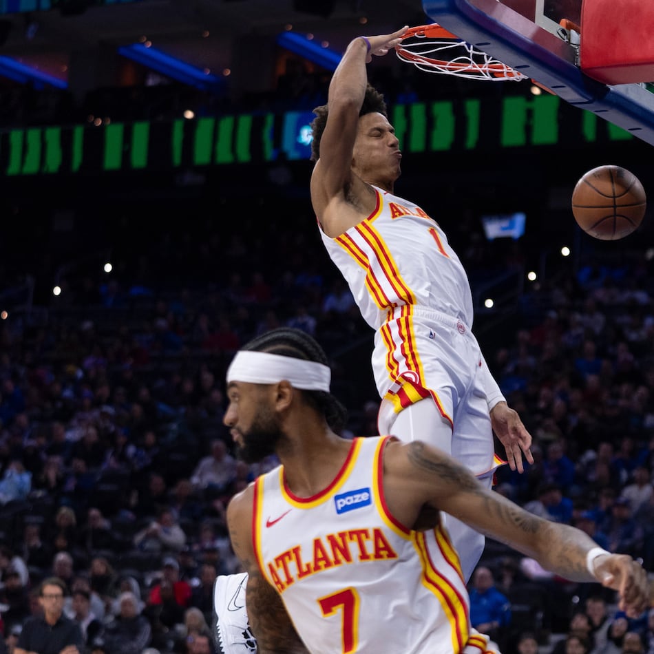 Atlanta Hawks' Jalen Johnson, right, dunks the ball from the pass by Nickeil Alexander-Walker, left, during the first half of an NBA basketball game against the Philadelphia 76ers, Sunday, Nov. 30, 2025, in Philadelphia. (AP Photo/Chris Szagola)