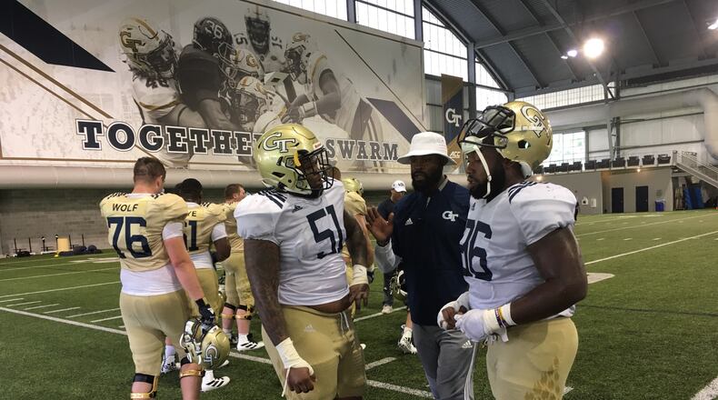 Georgia Tech defensive tackle/offensive tackle Jahaziel Lee (left) confers with defensive line coach Larry Knight middle and defensive tackle Chris Martin. (AJC photo by Ken Sugiura)