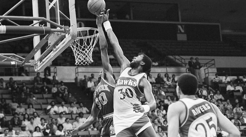 New York Knicks' Bernard King (30), left, has his shot blocked by Tree Rollins (30), right, of the Atlanta Hawks during first period action in New Orleans, La., Dec. 26, 1984. (AP Photo/Andrew J. Cohcon)