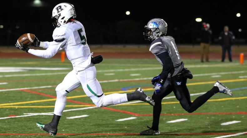 Roswell High School wide receiver Jayden Comma (5) completes a catch while being pursued by Westlake High School's Tre Person (1) during the second half of a semi-final high school football game, Friday, Dec. 2, 2016, in Atlanta. Roswell defeated Westlake 28-0. Branden Camp/Special
