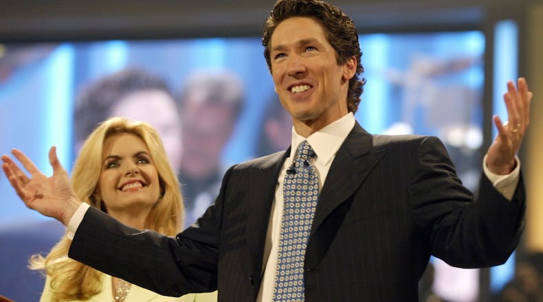 Televangelist and best-selling author, Joel Osteen, right, and his wife, Victoria, left, celebrate the grand opening of the new home for the Lakewood Church, formerly the Compaq Center, Saturday, July 16, 2005, in Houston. The arena that basketball fans once packed to see the NBA's Houston Rockets is taking on a new role, home to the largest congregation in the nation. It took more than 15 months and $75 million to convert the arena into the new home of the largest and fastest growing congregation in the nation.(AP Photo/Jessica Kourkounis)