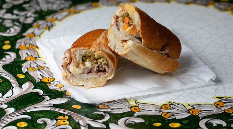 The spicy pork hero sandwich at E. 48th Street Market comes on an Italian roll and includes provolone slices, a drizzle of olive oil and a topping of chopped, hot-pepper relish. Courtesy of Erik Meadows