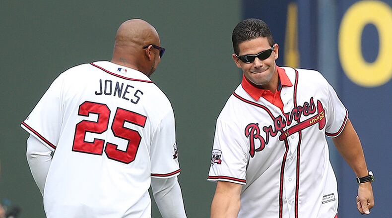 Braves greats Andruw Jones and Javy Lopez give each other five while taking the field for the team's final game at Turner Field on Sunday, Oct. 2, 2016, in Atlanta. (Curtis Compton/AJC)