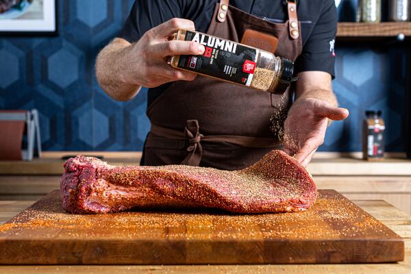 A Backyard Pitmasters instructor seasons brisket during a class. (Courtesy of Backyard Pitmasters)