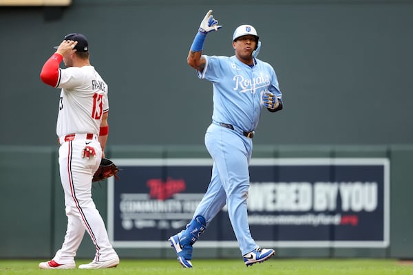 Kansas City Royals designated hitter Salvador Perez, right, celebrates his RBI single against the Minnesota Twins during the fifth inning of baseball game Saturday, May 24, 2025, in Minneapolis. (AP Photo/Matt Krohn)
