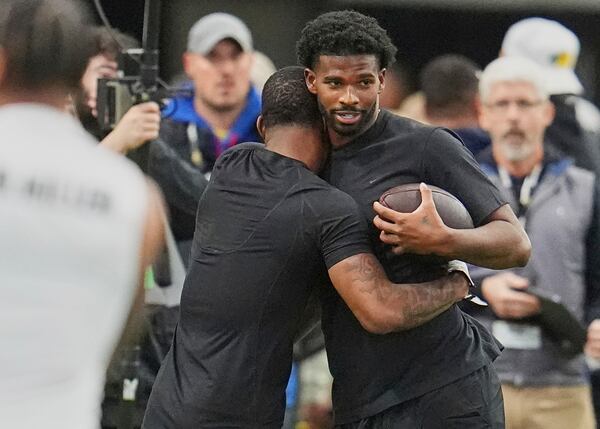 Colorado wide receiver LaJohntay Wester, left, hugs quarterback Shedeur Sanders before they take part in passing drills during Colorado's NFL football pro day Friday, April 4, 2025, in Boulder, Colo. (AP Photo/David Zalubowski)