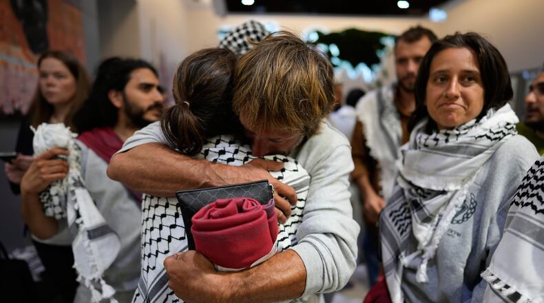 Activists from the Global Sumud Flotilla comfort each other upon their arrival at Istanbul Airport, in Istanbul, Turkey, Thursday, May 21, 2026. (AP Photo/Emrah Gurel)