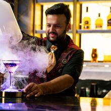 A bartender unveils a smoke-filled cocktail at Spellbound, where theatrical presentations are part of the immersive cocktail experience aboard the Star Princess. (Courtesy of Princess Cruises)