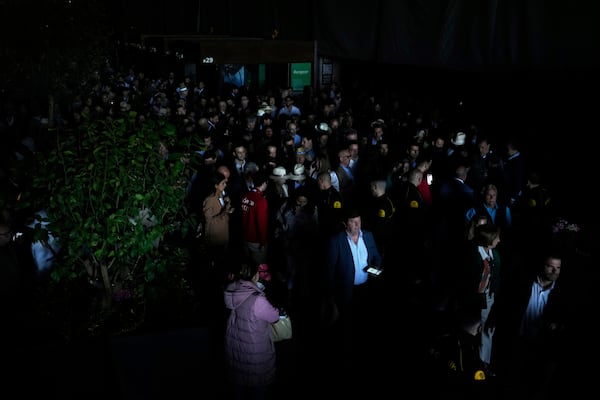 Spectators roam inside the Madrid Open tennis tournament venue during a general blackout in Madrid, Monday, April 28, 2025. (AP Photo/Manu Fernandez)