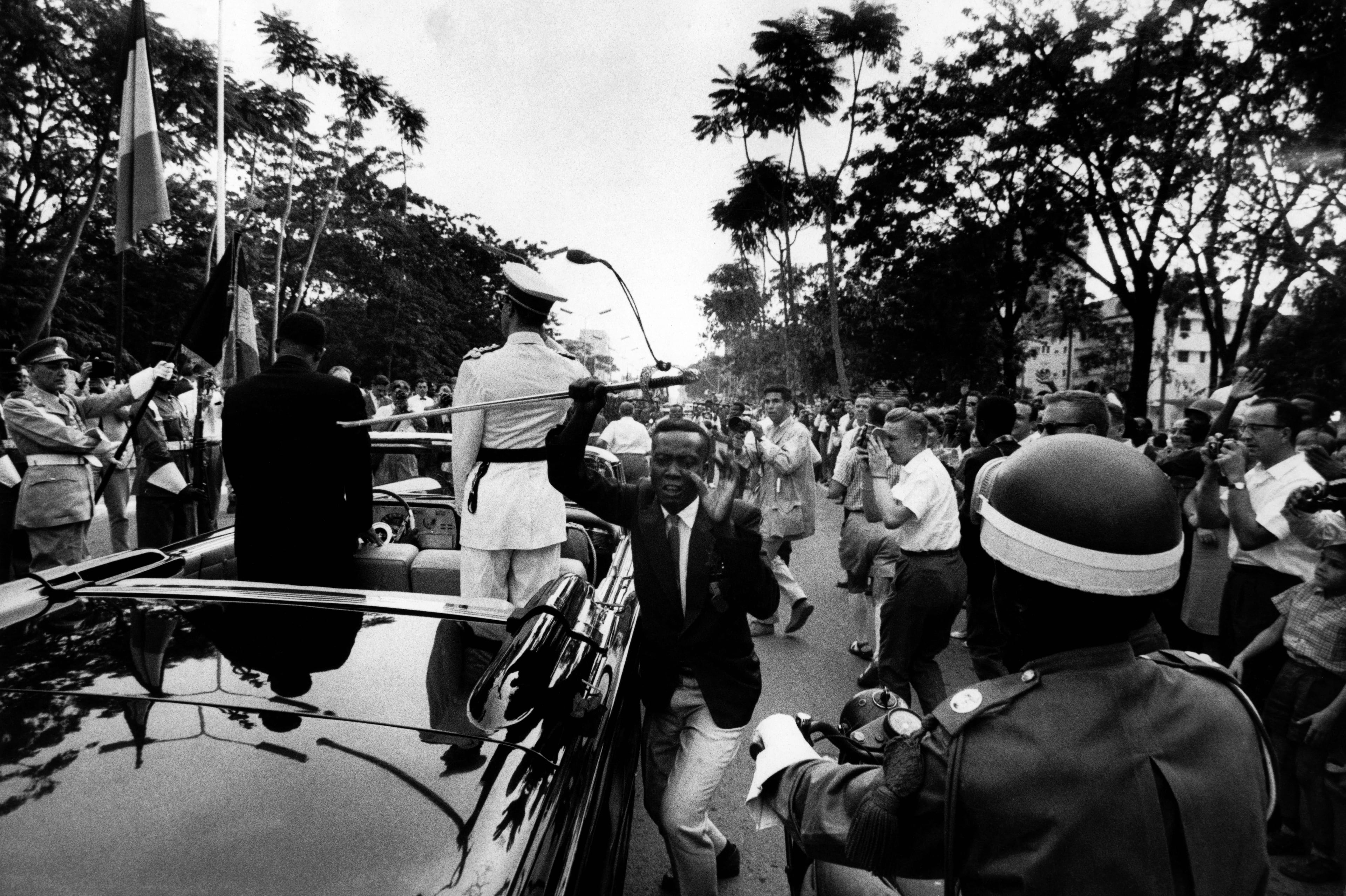 "Soundtrack to a Coup D'Etat" uses archival photos like this one to tell the narrative of global influence in Africa during the Cold War. In this 1960 photo, a Congolese man snatches a sword from King Baudouin of Belgium in Africa. (Courtesy of Robert Lebeck)