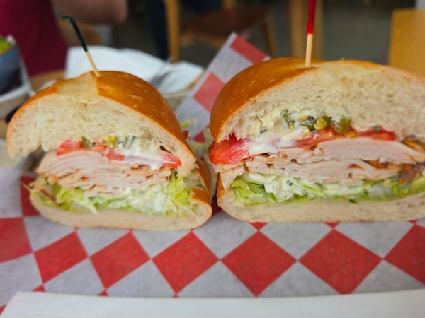 A turkey sub sandwich cut in half, the cut sides facing the camera.
