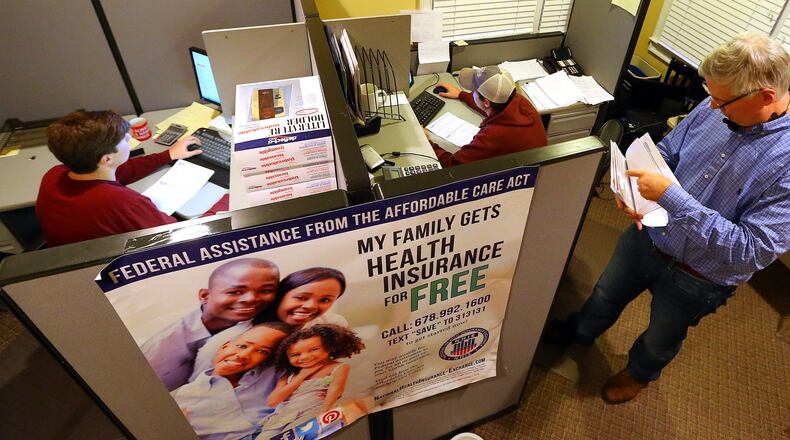 In 2013, just before Christmas Eve, Ted Officer (right) and his sons Christian and Graham worked late to process Affordable Care Act applications online for clients at USA-Health Insurance in Alpharetta. This year Georgia has experienced one of the biggest surges in Obamacare health coverage sign-ups in the nation. (CURTIS COMPTON / CCOMPTON@AJC.COM)