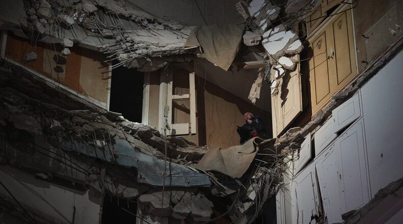 A woman stands at a destroyed apartment on a building that was hit in an Israeli airstrike in central Beirut, Lebanon, Wednesday, April 8, 2026. (AP Photo/Emilio Morenatti)