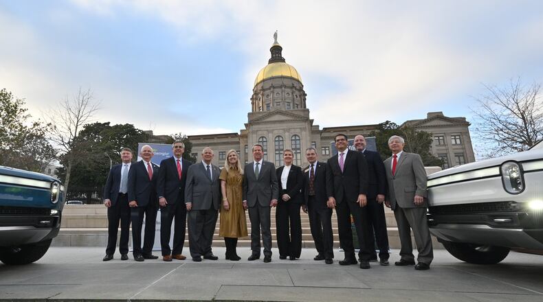December 16, 2021 Atlanta - Governor Brian Kemp (center) and Georgia lawmakers pose with Helen Russell, Chief People Officer at Rivian, during a press conference at Liberty Plaza across from the Georgia State Capitol in Atlanta on Thursday, December 16, 2021. Electric vehicle maker Rivian on Thursday confirmed its plans to build a $5 billion assembly plant and battery factory in Georgia, which Gov. Brian Kemp called Òthe largest single economic development project ever in this stateÕs history.Ó (Hyosub Shin / Hyosub.Shin@ajc.com)