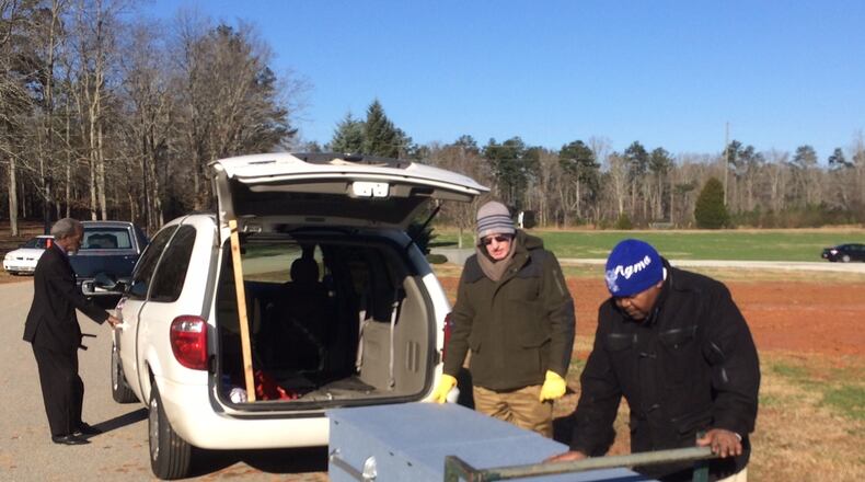 Rev. Cliff Dawkins, right, says a prayer over a coffin at Lakeside Memorial Gardens Cemetery two years ago.